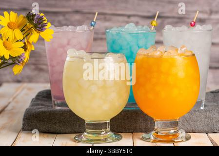 Mehrere Gläser mit Eis und Limonade in verschiedenen Geschmacksrichtungen und Farben. Stockfoto