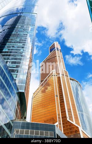 Flacher Blick auf moderne Wolkenkratzer vor blauem Himmel. Reflektierende Wolkenkratzer, Bürogebäude. Stockfoto