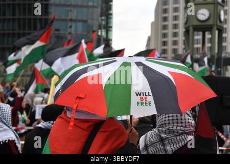 Berlin, Deutschland. Mai 2025. Demonstranten stehen mit Fahnen und Regenschirmen bei einer pro-palästinensischen Demonstration am Potsdamer Platz. Quelle: Paul Zinken/dpa/Alamy Live News Stockfoto