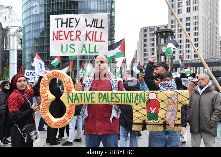 Berlin, Deutschland. Mai 2025. Demonstranten stehen bei einer pro-palästinensischen Demonstration am Potsdamer Platz. Auf einem Poster steht: „Sie werden uns nie alle töten“. Quelle: Paul Zinken/dpa/Alamy Live News Stockfoto