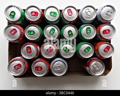 Eine Schachtel Limonade mit einer grünen und roten Dose oben. Die Dosen sind in einer Reihe angeordnet Stockfoto