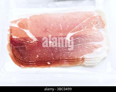 Ein Stück Fleisch mit weißem Hintergrund. Das Fleisch ist in Scheiben geschnitten und hat eine rosafarbene Farbe Stockfoto