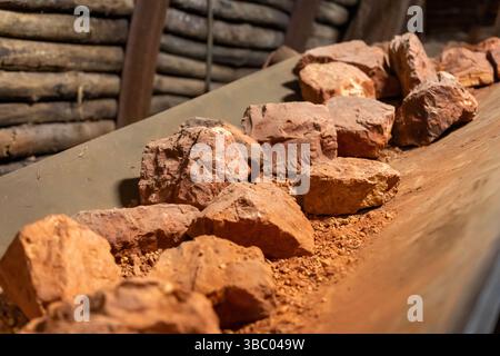 Bauxitgestein auf Förderband im Bergbautunnel Stockfoto