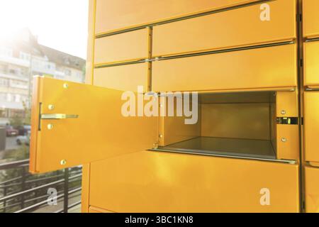 Gelbes modernes automatisches Postpostterminal mit Self-Service-Gerät für den Empfang einer Bestellung. Elektronisches Schließfach zur Aufbewahrung von Paketen auf der Straße Stockfoto