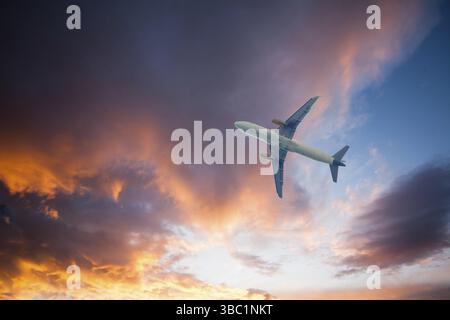 Kommerzielles Flugzeug am Himmel bei Sonnenuntergang. Blick vom Flughafen Stockfoto