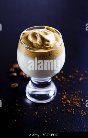 Dalgona-Kaffee: Instant-Mousse über die kalte Milch im Glas geschlagen Stockfoto