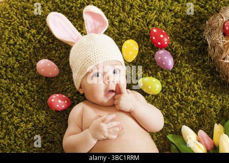 Drei Monate lang lag das Baby als Osterhase auf dem Teppich Stockfoto