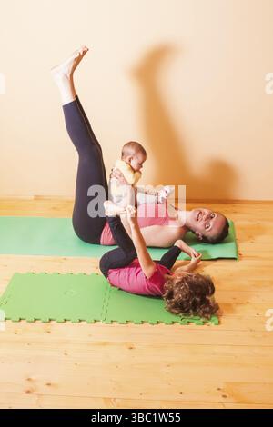 Mutter mit zwei Kindern Yoga Übungen in Home Stockfoto