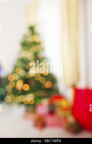 Weihnachtsbaum und Geschenke im Zimmer. Unscharfe Lichter Hintergrund für Design, Urlaubskonzept Stockfoto