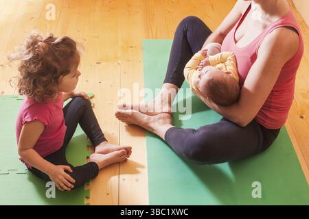 Mutter mit zwei Kindern Yoga Übungen in Home Stockfoto
