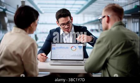 Diskussion Über Die Finanzielle Zukunft: Paar Trifft Sich Mit Hispanic Planner Im Amt Stockfoto