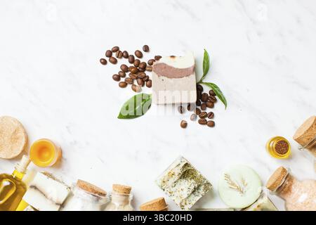 Weißer Kosmetikrahmen mit verschiedenen Assecorises. Seife mit Kaffee und Blättern. Sauberes Schönheitskonzept Stockfoto