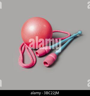 Turngeräte. Seilspringen, Schläger für rhythmische Gymnastik und Ball. Turnwerkzeuge isoliert auf grauem Hintergrund Stockfoto