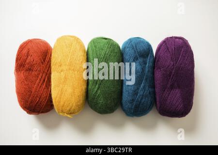 Kollektion von Fäden zum Stricken verschiedener Farben. Die flauschigen Fäden sind horizontal in einer Reihe angeordnet, isoliert auf weißem Hintergrund Stockfoto