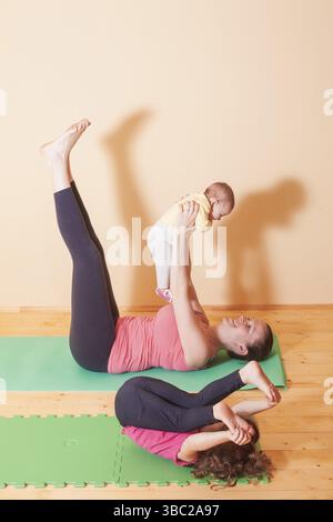 Mutter mit zwei Kindern Yoga Übungen in Home Stockfoto