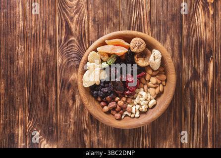 Trocknen Sie Früchte und Nüsse in der Schüssel auf einem Holztisch. Copy Space Hintergrund - Nahaufnahme gesunde Süßigkeiten Stockfoto