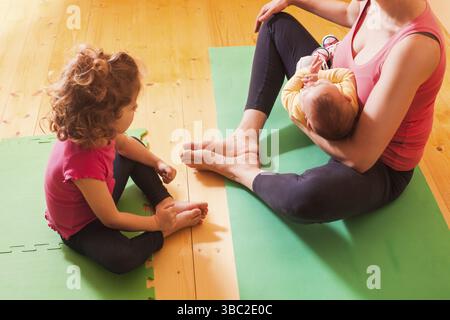 Mutter mit zwei Kindern Yoga Übungen in Home Stockfoto
