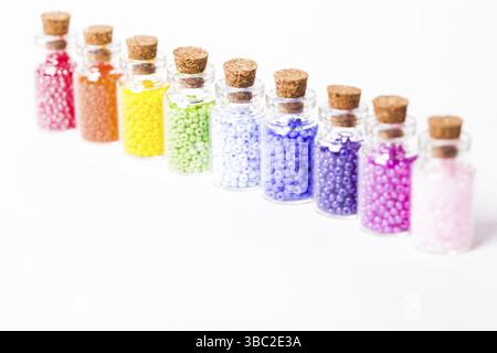 Perlen im Vintage mini Glas Flaschen mit Naturkorken isoliert auf weißem Stockfoto