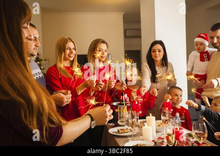 Frohe Weihnachten und frohes neues Jahr. Eine große Familie mit Glitzern, die Spaß auf der weihnachtsfeier haben Stockfoto