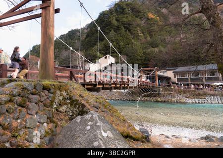 Nagano, JAPAN – 12. November 2024: Kappa Bashi Brücke über das klare Wasser des Flusses Azusa mit Bergen und Himmel in Kamikochi, Präfektur Nagano, Japan Stockfoto