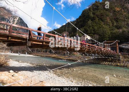Nagano, JAPAN – 12. November 2024: Kappa Bashi Brücke über das klare Wasser des Flusses Azusa mit Bergen und Himmel in Kamikochi, Präfektur Nagano, Japan Stockfoto