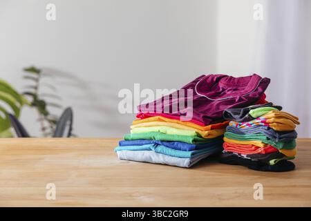 Ein übersichtliches Set aus mehrfarbigen T-Shirts und Socken für Kinder, mit denen sie ihr Outfit ganz einfach auswählen können. Das erleichtert den Alltag. Legere Garderobe auf einem Woode Stockfoto