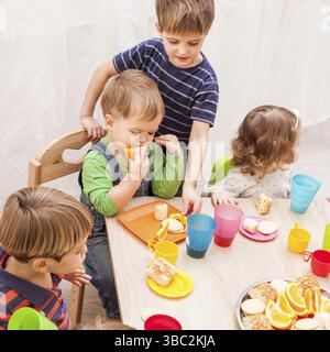 Gruppe von glücklichen Kindern genießen Party am Geburtstag im Kindergarten Stockfoto