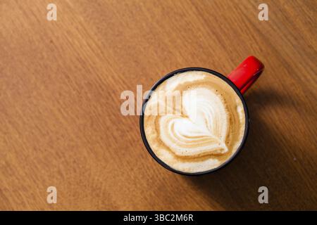 Tasse Latte Art Kaffee mit Herzform auf Holztisch Stockfoto