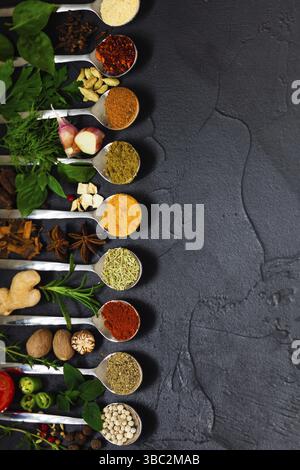 Verschiedene Gewürze und Kräuter auf schwarzem Hintergrund, Draufsicht, Kopierbereich Stockfoto