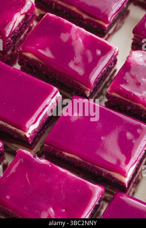 Die Nahaufnahme von Cakes Opera mit rosa Sahne. Die köstlichen, mehrlagigen Kuchen werden hintereinander angerichtet Stockfoto