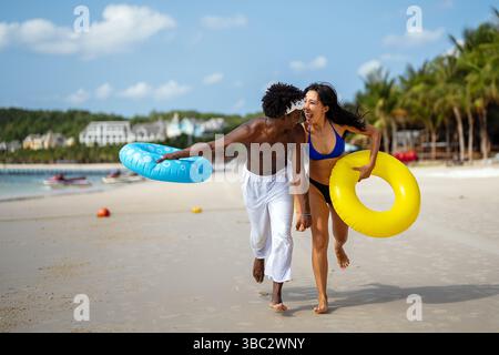 Reines Glück. Ein junges, vielseitiges, multiethnisches Paar genießt jeden Moment ihres tropischen Urlaubs Stockfoto