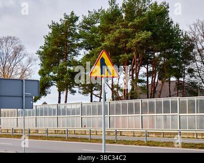 Straßenschild Warnung vor Zusammenführen von Verkehr vor sich Stockfoto