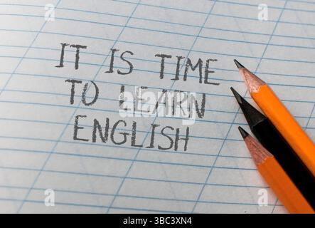 Bleistift und ein Bleistiftspitzer sind auf einem Blatt Papier mit den Worten es ist Zeit, Englisch zu lernen Stockfoto