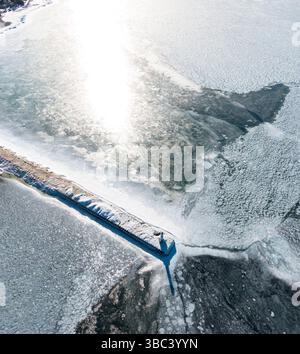Aus der Vogelperspektive eines Leuchtturms, umgeben von gefrorenem Wasser im Winter Stockfoto