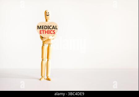 Medizinethik-Symbol. Konzeptworte medizinische Ethik am schönen hölzernen Herzen. Arztmodell. Schöner weißer Hintergrund. Kopierbereich. Medizinisch gesund Stockfoto
