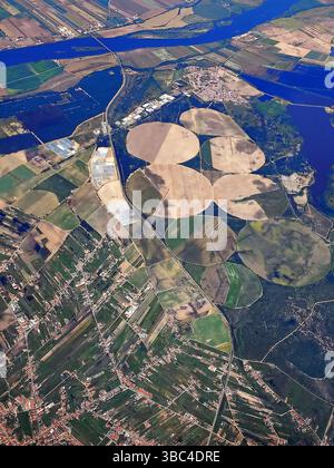 Einzigartige Luftperspektive mit kreisförmigen Ackerflächen in der Nähe von Flüssen und ländlichen Städten mit sichtbaren Rastermustern und Kontrasten in den Farben Stockfoto