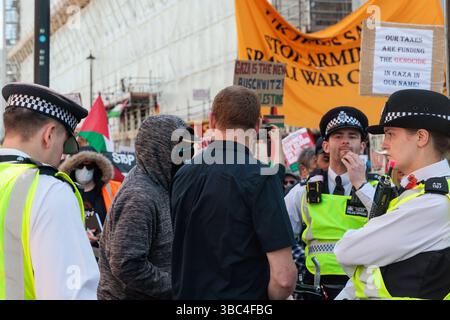 London, Großbritannien. Mai 2025. Polizeibeamte überwachen den pro-israelischen Aktivisten Mark Birbeck und einen maskierten Gegenprotestierenden neben ihm, während Hunderttausende pro-palästinensische Demonstranten eine große Demonstration anlässlich des 77. Jahrestages der Nakba abgeben. Der Nakba-Tag am 15. Mai erinnert an die Massenvertreibung und Enteignung einer Mehrheit des palästinensischen Volkes und die Zerstörung der palästinensischen Gesellschaft im Jahr 1948. Quelle: Mark Kerrison/Alamy Live News Stockfoto