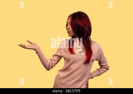 Rothaarige Frau mit geöffneter Hand, die nachdenklich aussieht Stockfoto