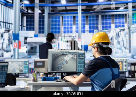 Photovoltaik-Fabrikingenieur mit grüner Energie passt Systemparameter am PC an, um die Stromerzeugung zu maximieren. Techniker, der die Energieversorgung in einer umweltfreundlichen Produktionsanlage für Solarmodule optimiert Stockfoto