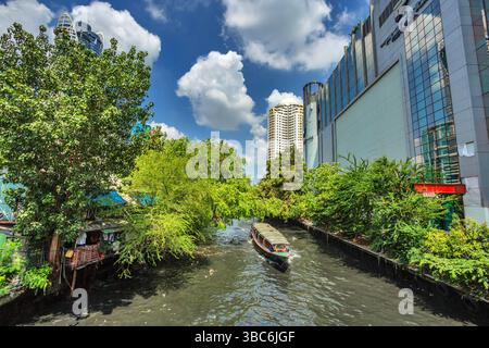 BANGKOK, THAILAND - 29. APRIL 2015: Ein Kanalboot auf Klong Saen Saep erreicht einen Pier im Bezirk Pratunam in Bangkok, Thailand. Klong Saen Saep Canal ru Stockfoto