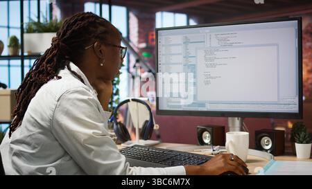 Kodierer am Arbeitsplatz Programmierung auf PC, Schreiben von Codezeilen, Verwenden von Entwicklungstools, Stressgefühl. Frau im Heimbüro mit Deadline, Stress, Debugging-Software fertig zu stellen, Kamera A Stockfoto