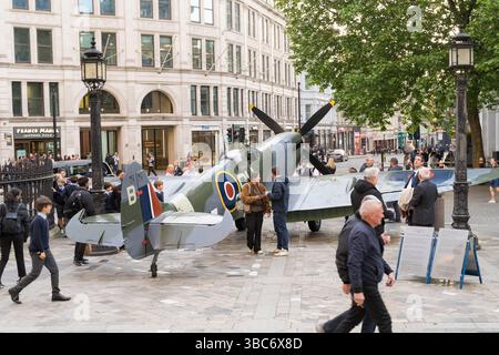 Eine Menschenmenge versammelt sich, um ein Spitfire-Flugzeug zu sehen, das vor der St. Paul’s Cathedral in London im Rahmen des 80. VE Day WWII Jubiläums in London gezeigt wurde Stockfoto