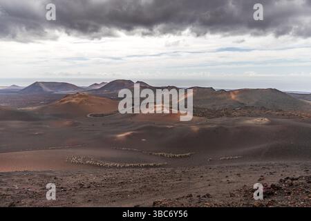 Vulkanlandschaft auf Lanzarote, Spanien. Vulkanische Hügel und Krater prägen die Landschaft. Camino Pista Rural Ruta de los Volcanes, Yaiza, Canarias, Spanien Stockfoto