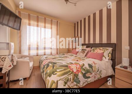 Klassisch eingerichtetes Schlafzimmer mit Doppelbett und schwarzem Metallkopfteil Stockfoto