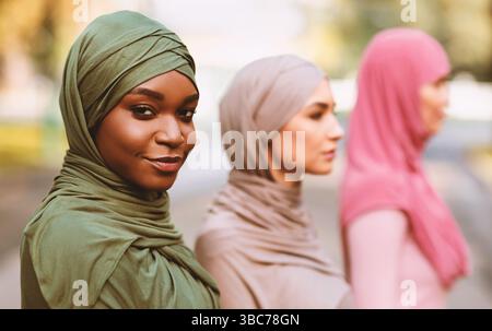 Schwarz Muslimische Frau Posiert Mit Verschiedenen Islamischen Damen Im Freien Stehen Stockfoto