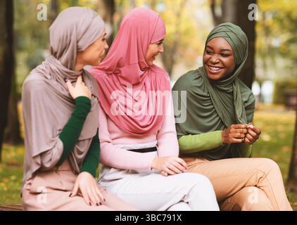 Multiethnische Islamische Frauen Im Freien Sitzen Auf Einer Bank Im Park Stockfoto