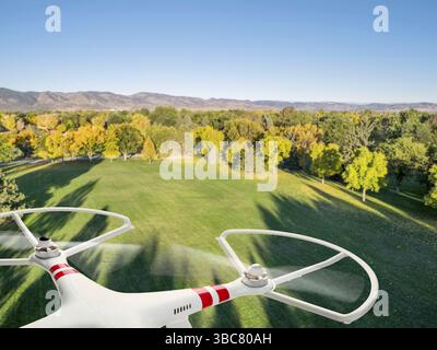 Drohne fliegt in Herbstfarben unter Morgenlicht mit tiefen, langen Schatten über den Park Stockfoto
