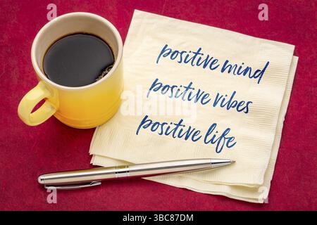 Positiver Geist, positive Vibes, positives Leben - motivierende Handschrift auf einer Serviette mit einer Tasse Kaffee Stockfoto