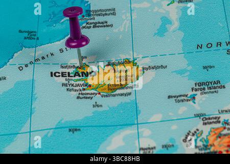 Eine Karte konzentriert sich auf Island, wobei Reykjavik mit einer lila Stecknadel hervorgehoben wird, die die geografische Lage der Insel im Nordatlantik unterstreicht. Stockfoto