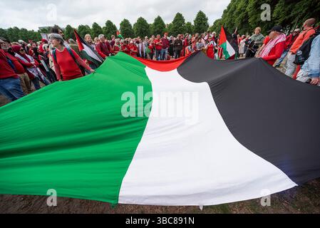 Die Demonstranten halten eine große palästinensische Nationalflagge auf Malieveld, bevor sie während der Demonstration der „ROTEN LINIE“ zum Internationalen Gerichtshof gehen. Zehntausende Demonstranten gingen auf die Straßen der Haag und protestierten gegen die Haltung der niederländischen Regierung zu Israel. Die Organisatoren schätzten die Beteiligung von rund 80 Personen auf etwa 100.000 Personen, eine Zahl, die von der Polizei nicht bestätigt wurde, die aber die größte seit 20 Jahren war. Die Demonstranten trugen die Farbe Rot, um die „Rote Linie“ zu symbolisieren, die vom Schoof-Kabinett hätte gezeichnet werden sollen. Der Dämon Stockfoto